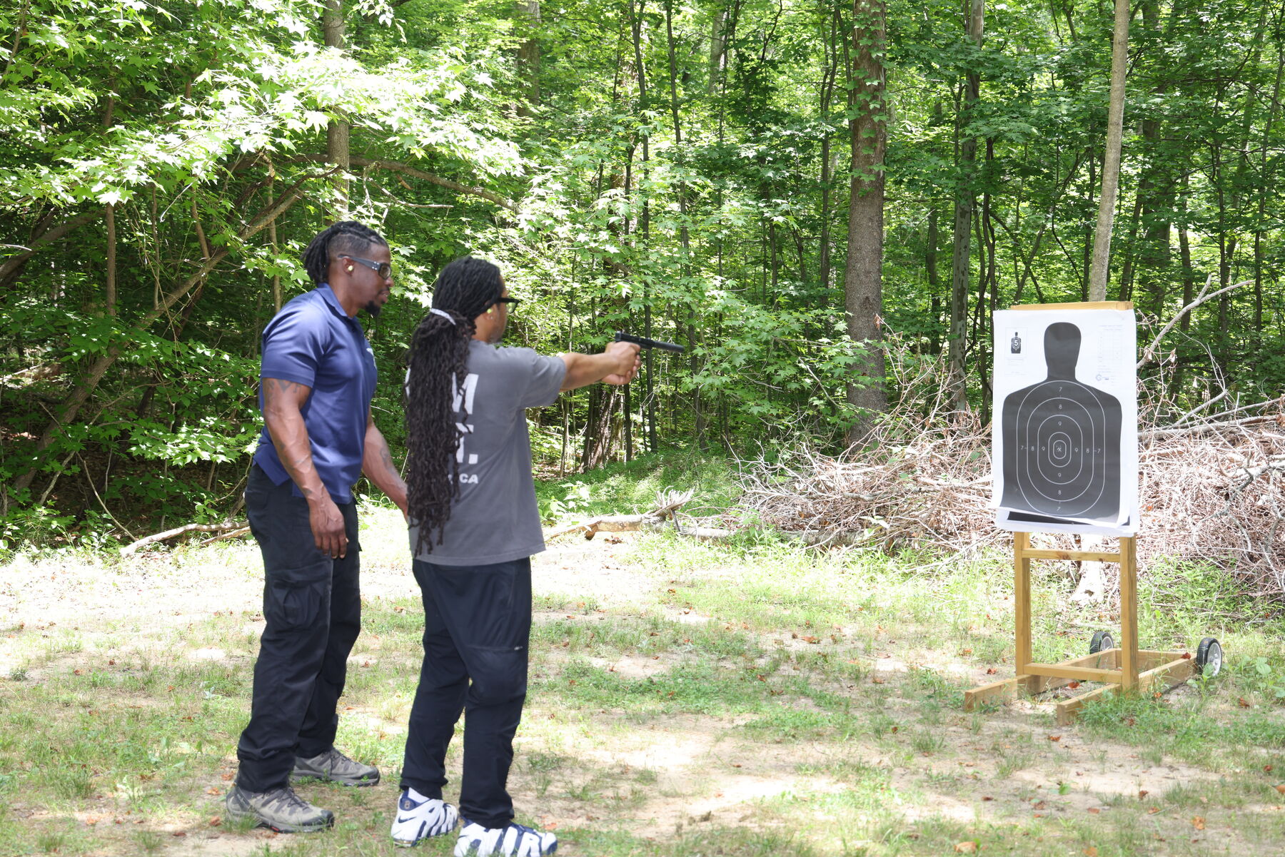 Student practicing sight alignment with instructor support